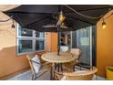 Cozy patio seating area with an umbrella, cafe lights and an outdoor heater at 801 Confidence Dr # 2, Longmont, CO 80504