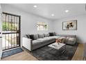 Cozy living room with a modern sectional sofa, stylish area rug, and bright natural light at 2621 S Federal Blvd, Denver, CO 80219