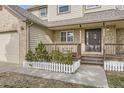 Inviting front porch with wood railings, steps and a decorative white picket fence lining the front of the home at 49950 Oak Park Dr, Bennett, CO 80102