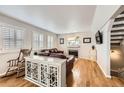 Cozy living room featuring hardwood floors, a fireplace, and bright white trim for an inviting ambiance at 49950 Oak Park Dr, Bennett, CO 80102