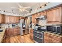Well-lit kitchen featuring stainless steel appliances, granite countertops and wooden cabinets at 6367 Xavier St, Arvada, CO 80003