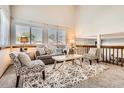 Bright living room with high ceilings, large windows, comfortable seating, and stylish decor at 6367 Xavier St, Arvada, CO 80003