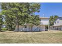 Charming two-story home with white siding and a lush green lawn and mature tree at 62 Newark St # D, Aurora, CO 80012
