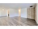 A spacious living room boasts modern flooring and a brick accent wall at 62 Newark St # D, Aurora, CO 80012