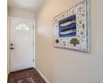 Welcoming foyer with a white front door, tile flooring, and a decorative piece of artwork at 4028 Ames St, Wheat Ridge, CO 80212