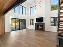 Bright living room with hardwood floors, fireplace, and large windows with sliding doors to the outside at 5326 Lions Paw St, Castle Rock, CO 80104