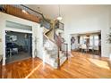 Elegant foyer showcasing curved staircase, hardwood floors, and views into dining and living spaces at 7408 Sodalite Way, Castle Rock, CO 80108