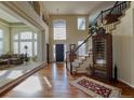 A grand two-story foyer with hardwood floors, an elegant staircase, and a living room entrance at 7408 Sodalite Way, Castle Rock, CO 80108
