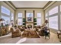 Formal living room with large windows, a fireplace, and traditional-style furnishings at 7408 Sodalite Way, Castle Rock, CO 80108
