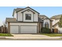 Charming two-story home with a two-car garage, manicured lawn, and beautiful architectural details at 3823 S Uravan St, Aurora, CO 80013
