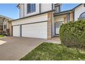 Two-story home with a three-car garage, tidy lawn, and brick detailing around the entrance at 3823 S Uravan St, Aurora, CO 80013