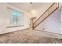 Living room featuring carpet, stairs, and a half moon window at 3823 S Uravan St, Aurora, CO 80013