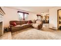 Inviting living room with a large brown sectional, fireplace, neutral carpet, and natural light at 3823 S Uravan St, Aurora, CO 80013