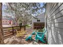 Side yard featuring a wooden fence, multiple seating areas and shade from mature trees at 4521 E Jewell Ave, Denver, CO 80222