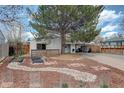 Front exterior showcasing mature tree and well-manicured landscaping including decorative rocks and garden beds at 4521 E Jewell Ave, Denver, CO 80222