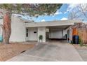 Exterior shot showing front entrance, covered parking, brick pillar, and well-maintained yard at 4521 E Jewell Ave, Denver, CO 80222