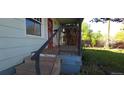 Quaint front porch with rustic railing and steps, inviting you to relax and enjoy the outdoors at 4635 Teller St, Wheat Ridge, CO 80033