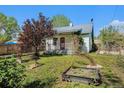 Charming home featuring a landscaped front yard with decorative trees and a classic red front door at 4635 Teller St, Wheat Ridge, CO 80033