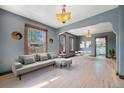 Bright living room with hardwood floors, classic light fixtures, and natural light from large windows at 4635 Teller St, Wheat Ridge, CO 80033