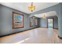 Bright living room with hardwood floors, classic light fixtures, and natural light from large windows at 4635 Teller St, Wheat Ridge, CO 80033