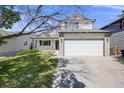 Traditional two-story home featuring manicured lawn and a two car garage in suburban neighborhood at 11727 Oswego St, Commerce City, CO 80640