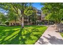 Exterior view of building with manicured lawn and mature trees, showing pedestrian path at 7040 E Girard Ave # 207, Denver, CO 80224
