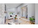 Bright living room with modern decor and open floor plan leading to staircase at 3883 S Fraser St, Aurora, CO 80014