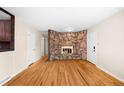 Bright living room featuring hardwood floors, a unique stone fireplace, and ample natural light at 625 Ammons St, Lakewood, CO 80214