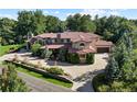 Beautifully landscaped home featuring a circular driveway, mature trees and attached three-car garage at 2 Viking Dr, Englewood, CO 80113