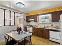 Charming kitchen with patterned wallpaper, vintage cabinets, and a bright window overlooking the yard at 3018 S Depew St, Denver, CO 80227