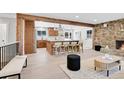 Open-concept living room and kitchen with stone fireplace, wood accents, and hardwood floors at 1189 Lodgepole Dr, Evergreen, CO 80439