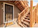 Close up of the front door and wooden stairs leading to the unit entrance at 2296 S Pitkin Way # A, Aurora, CO 80013