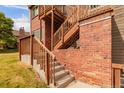 Brick and wood townhome exterior featuring a wooden staircase and concrete steps at 2296 S Pitkin Way # A, Aurora, CO 80013