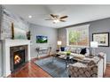 Comfortable living room featuring a fireplace, large window, and stylish furniture on hardwood floors at 602 Mathews Way, Erie, CO 80516