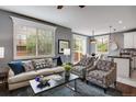 Bright living room with ample natural light, comfortable seating, and seamless flow to dining area at 602 Mathews Way, Erie, CO 80516