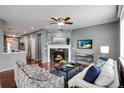 Inviting living room featuring a fireplace, ceiling fan, and comfortable seating at 602 Mathews Way, Erie, CO 80516