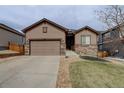 Attractive single-Gathering home featuring a well-maintained lawn, stone accents, and a spacious driveway at 7809 Bandit Dr, Castle Rock, CO 80108