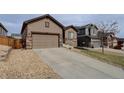 Inviting home featuring a two-car garage, complemented by stone landscaping at 7809 Bandit Dr, Castle Rock, CO 80108