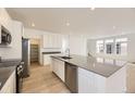 Modern kitchen boasts stainless steel appliances, a large island, and ample cabinet space at 7293 Waterleaf Trl, Littleton, CO 80125