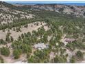 Expansive aerial view of a home surrounded by lush greenery and mountainous terrain at 2122 Montane Dr, Golden, CO 80401
