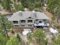 Aerial view of a house with a spacious deck, hot tub, large windows and a tiled roof at 2122 Montane Dr, Golden, CO 80401
