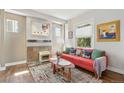 Cozy living room with bright red sofa, colorful accents, fireplace, and a sun-lit window at 1686 S Logan St, Denver, CO 80210