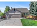 Charming single-story home with a two-car garage, well-manicured lawn, and inviting front porch at 11076 Cotton Creek Dr, Westminster, CO 80031
