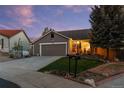 Charming single-story home with a two-car garage, well-manicured lawn, and inviting front porch at 11076 Cotton Creek Dr, Westminster, CO 80031
