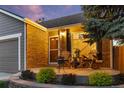 Inviting front porch with brick detail, rocking chairs, and tasteful landscaping at 11076 Cotton Creek Dr, Westminster, CO 80031