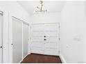 Bright entryway with white double doors, closet and modern light fixture at 3957 S Peach Way, Denver, CO 80237