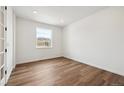 Bright bedroom with a large window, wood flooring, and neutral walls, ready for personalization at 24748 E 40Th Ave, Aurora, CO 80019