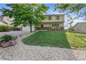 Charming two-story home featuring a well-kept lawn and rock landscaping at 874 Mercury Cir, Lone Tree, CO 80124
