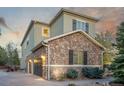 Exterior view showing the two-car garage and detailed stone on this home's facade at 20148 E Windy Pine Pl, Parker, CO 80134