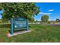 Sign for Denver's Washington Park set against the backdrop of lush greenery and a lake at 480 S Marion Pkwy # 901, Denver, CO 80209